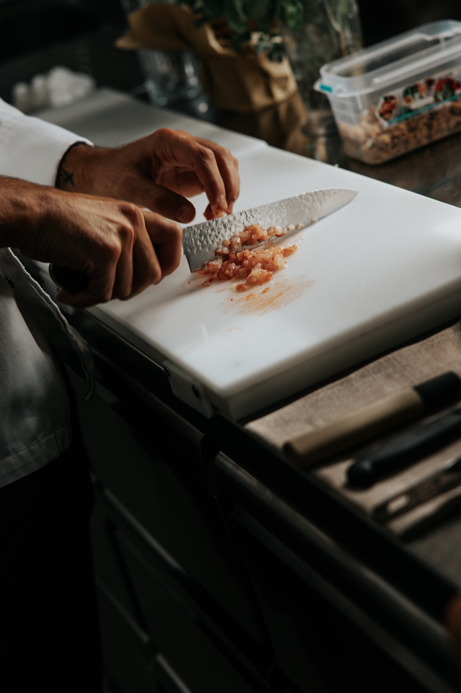 Le mani dello chef preparano il pesce fresco in cucina