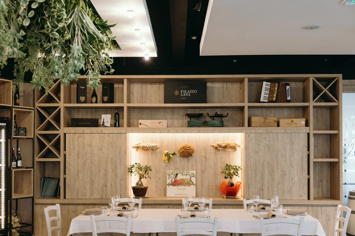 La sala del ristorante, legno chiaro e tavole apparecchiate